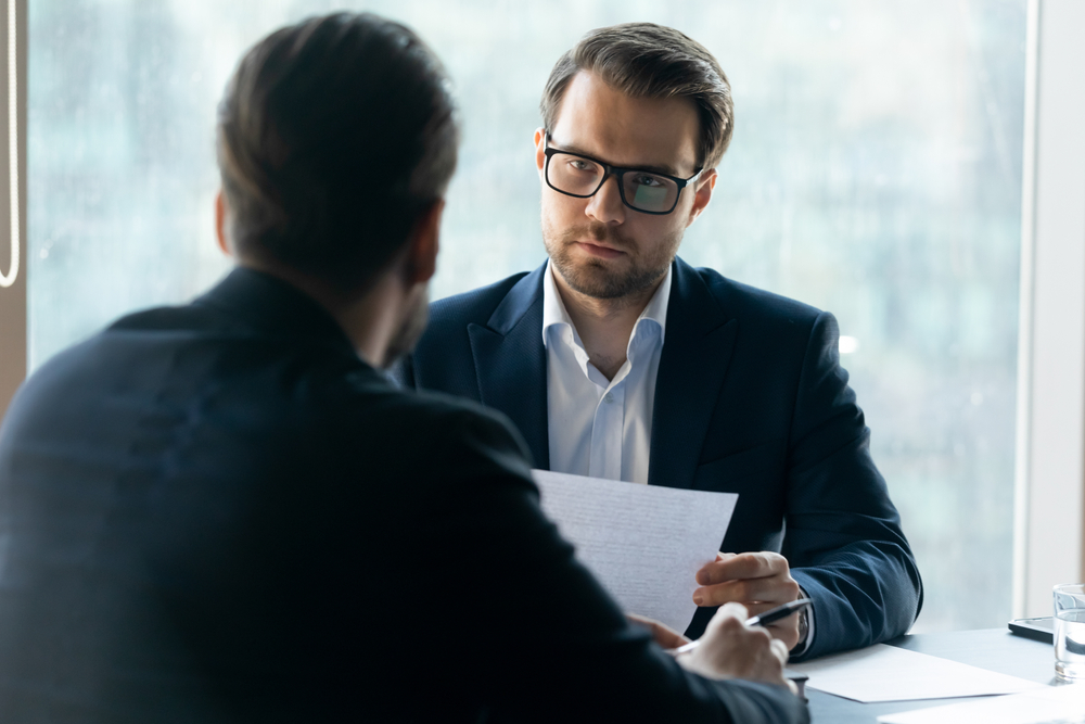 HR manager wearing glasses looking at job applicant