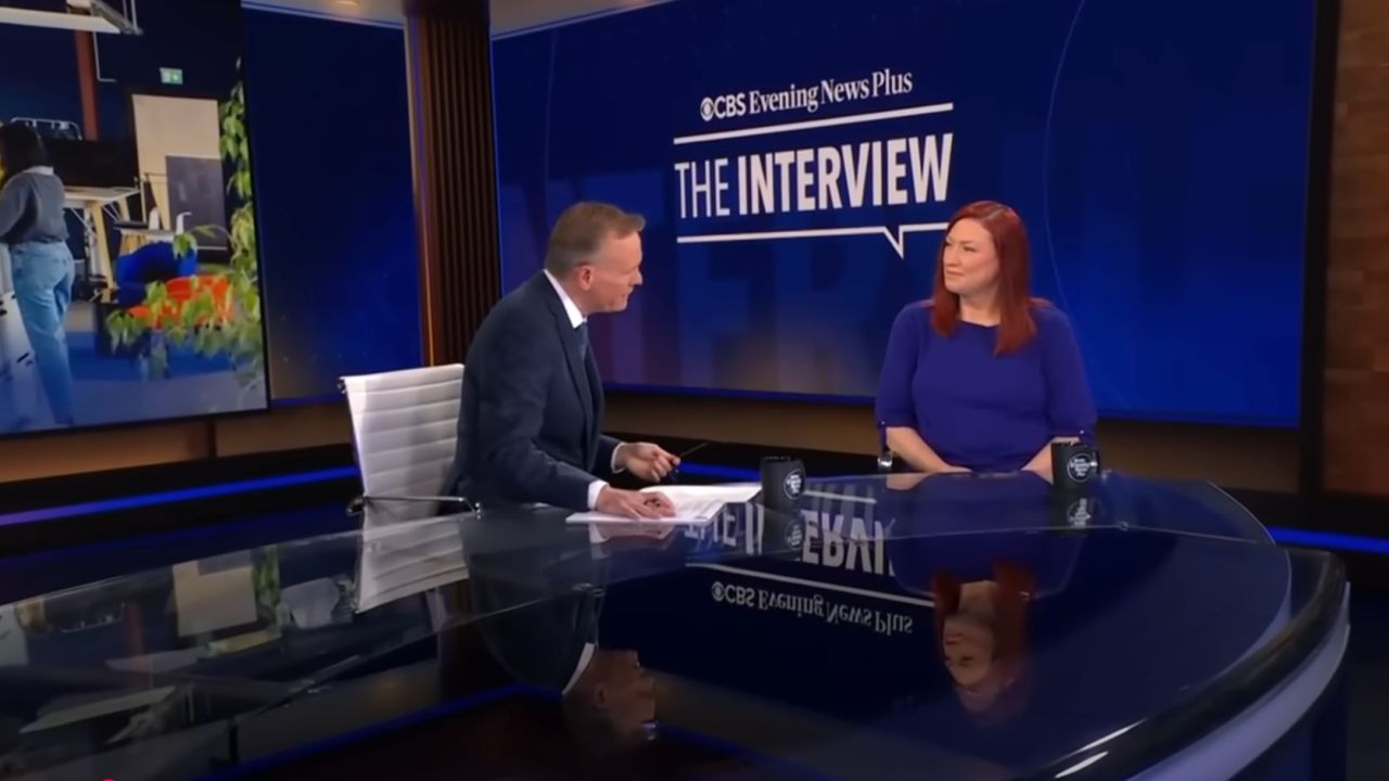 Allison, CEO of Tallo, sits for an interview on the CBS Evening News Plus set. She speaks with the host across a glass news desk, with “The Interview” displayed on a large screen behind them.