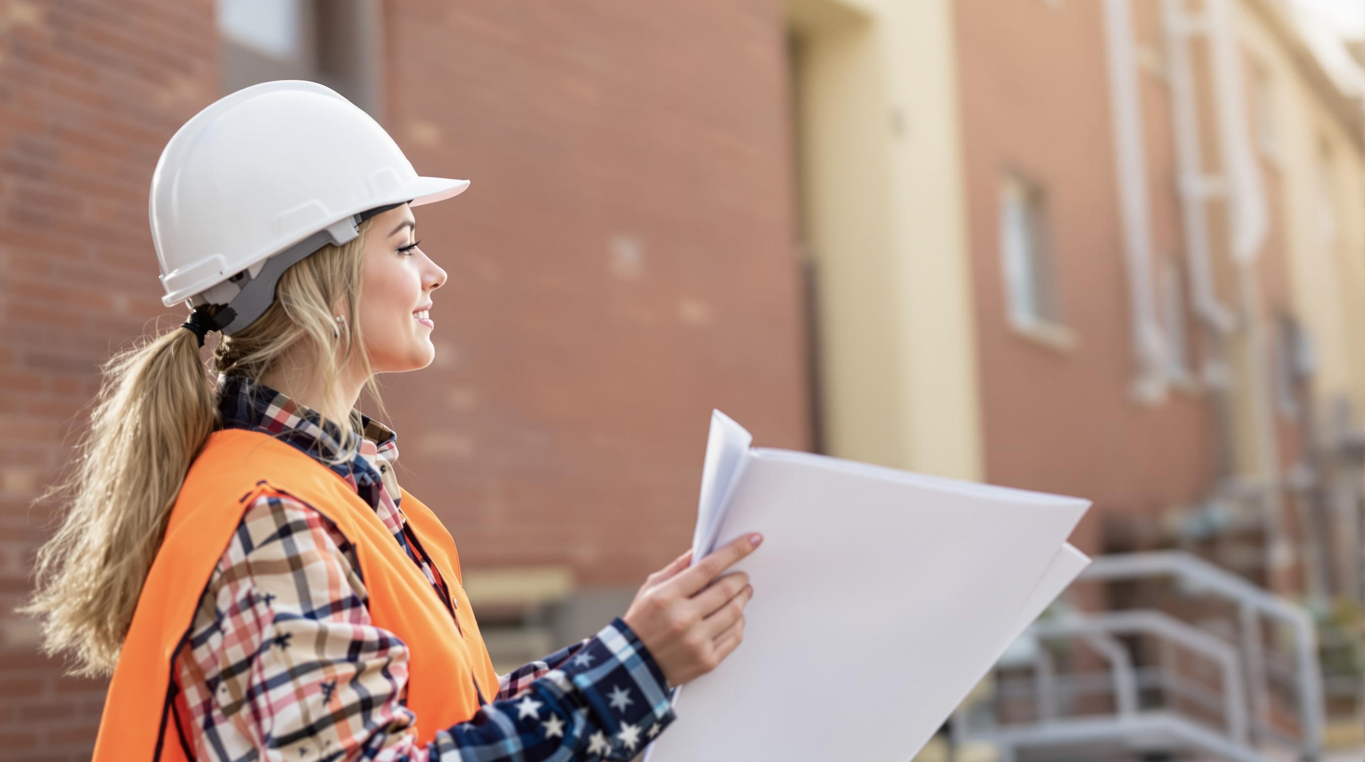 Property Insurer Looking at a Building A female property insurer inspecting a building for insurance purposes.