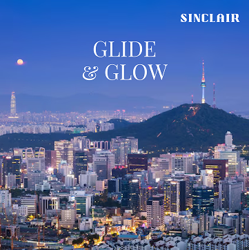 City skyline at dusk with glowing office lights and a mountain topped with a lit tower rising above the buildings under a deep blue evening sky. White text reads Glide and Glow with the artist name Sinclair at the top, giving the image a polished album cover aesthetic.