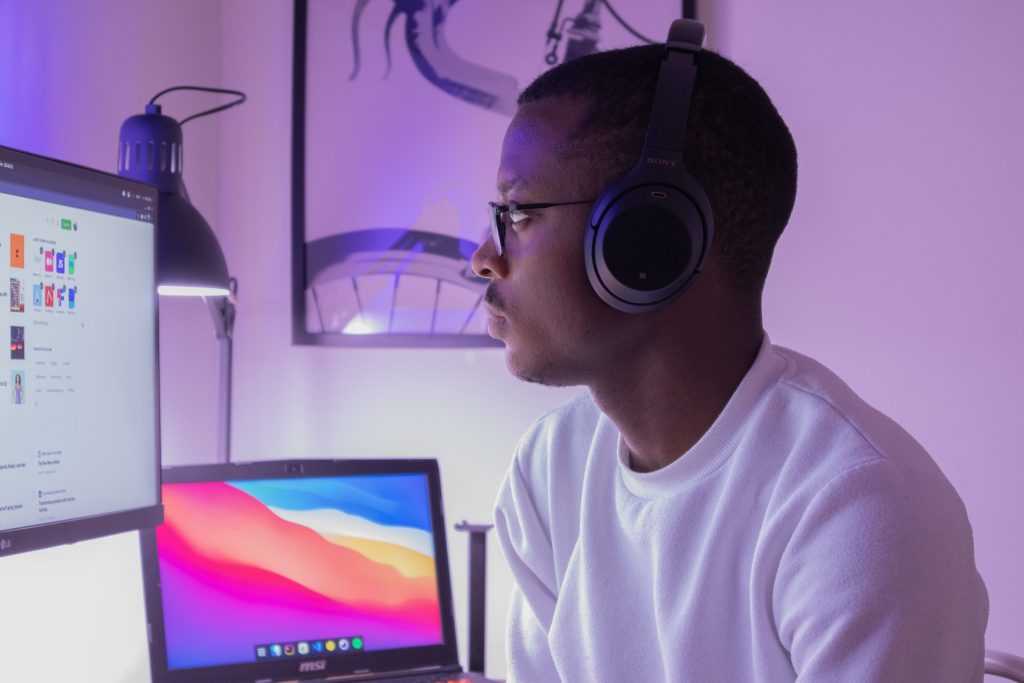 Visual artist working on his computer with headphones on.