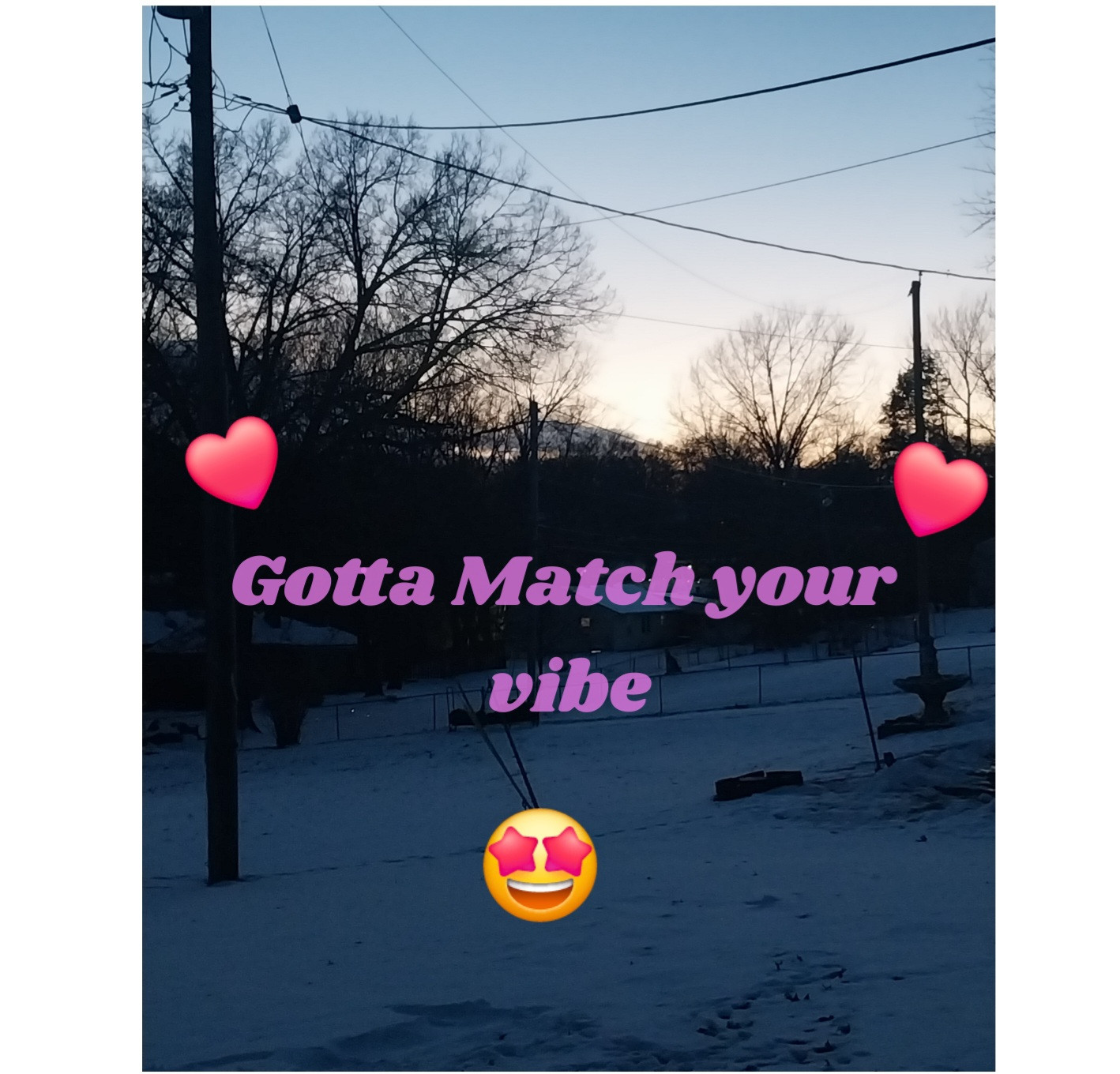 Snow covered yard at dusk with bare trees and power lines silhouetted against a fading blue and orange sunset sky. Purple text across the center reads Gotta Match your vibe with two pink heart graphics and a smiling face with star eyes emoji layered over the winter scene.