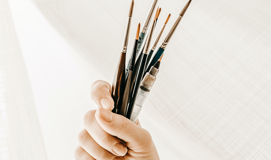 hand with paintbrushes