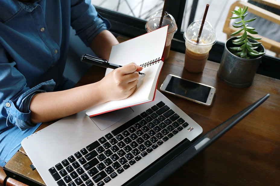 business woman hand multitasking using phone and working on laptop connecting wifi internet and coffee cup, businesswoman busy hardworking write pen on notebook at office desk background